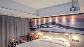 Una habitación de hotel con una cama, un escritorio, una silla, una mesita de noche y un mural grande en la pared.