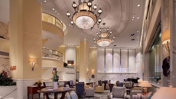 A spacious lobby with a grand chandelier, marble floors, and a curved staircase. - Hotel Royal Macau (Macau)