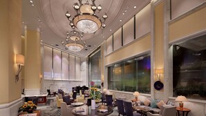 A spacious lobby with a chandelier, comfortable seating, and large windows. - Hotel Royal Macau (Macau)