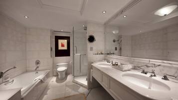 A modern bathroom with a large bathtub, a walk-in shower, and a double sink vanity.