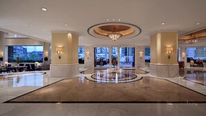 A spacious lobby with a marble floor, large windows, and a central chandelier. - Hotel Royal Macau (Macau)