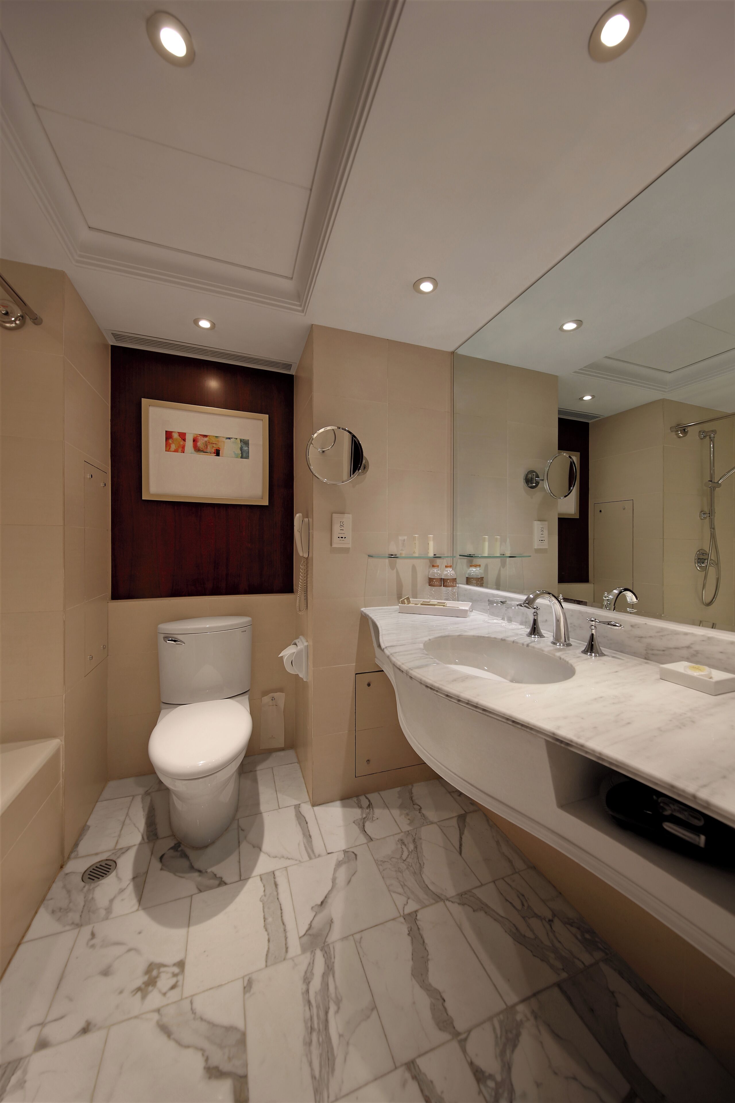 A modern bathroom with a marble sink, a toilet, and a shower.