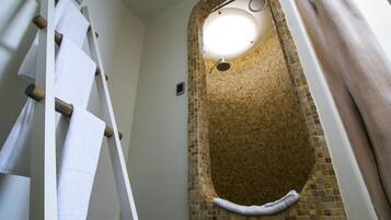 A bathroom with a freestanding bathtub, a towel rack, and a showerhead.