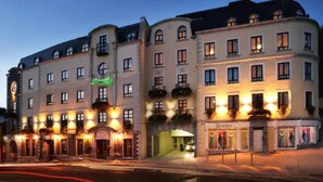 A multi-story hotel with a classic European architectural style, featuring balconies and a ground-level storefront. - Bracken Court Hotel (Balbriggan)