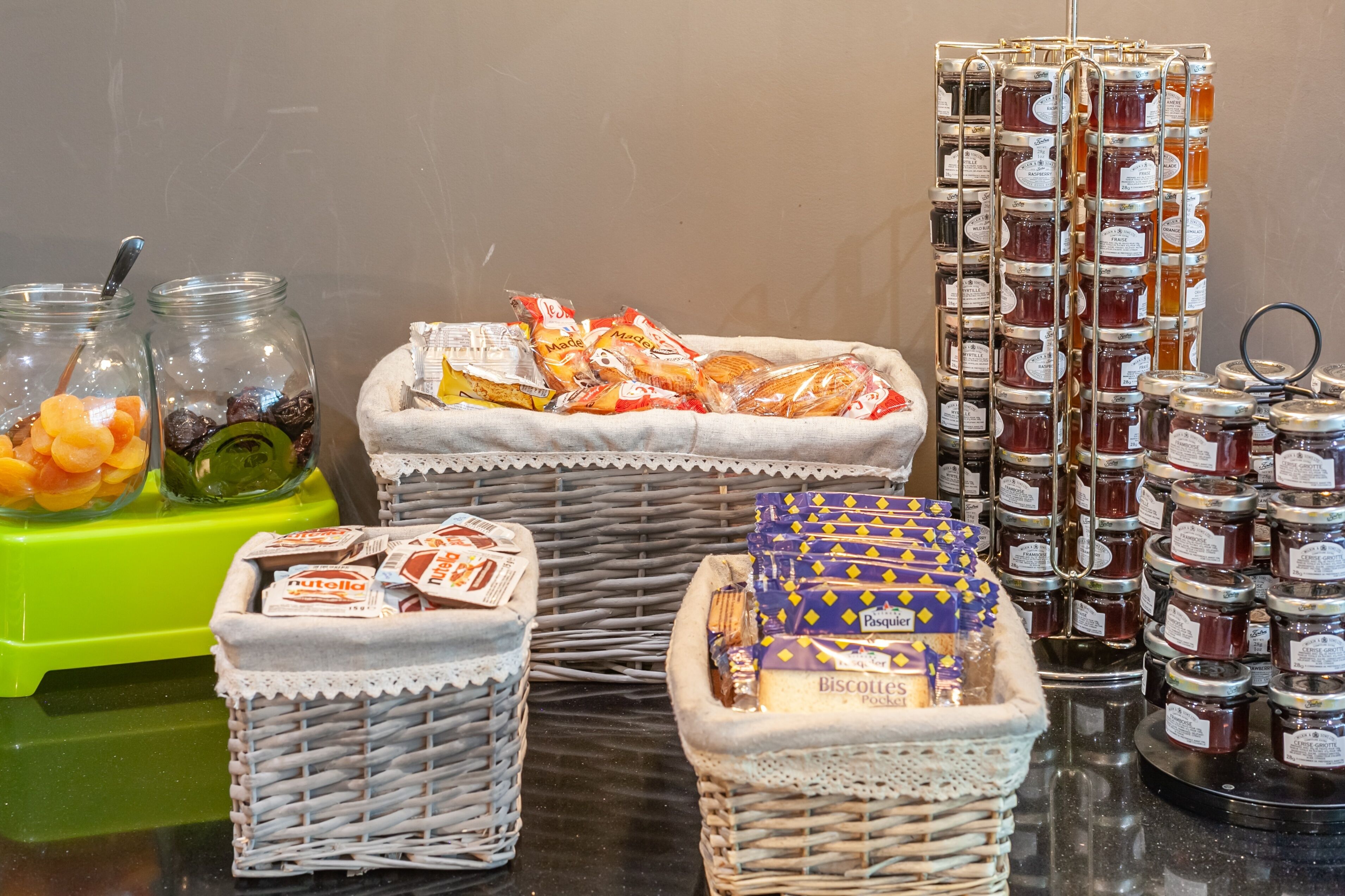 A variety of food items including jars of honey, packets of biscuits, and bags of snacks.