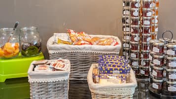 A variety of food items including jars of honey, packets of biscuits, and bags of snacks.