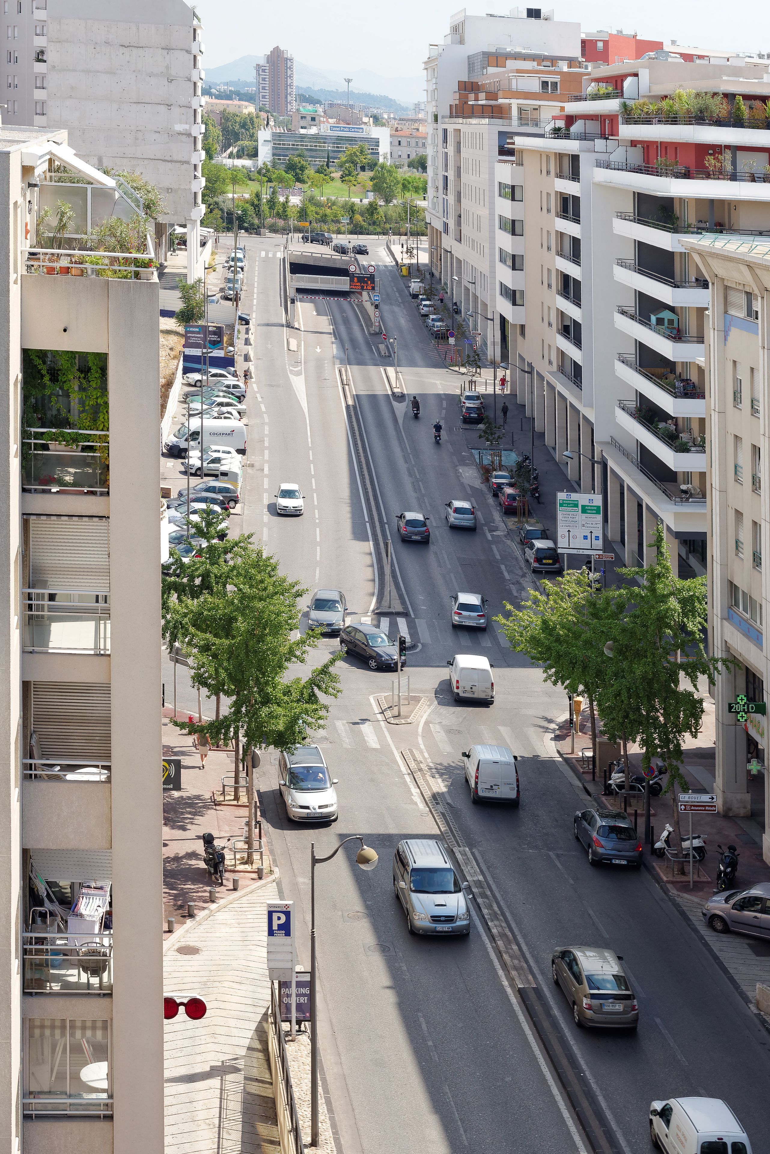 Eine mehrstöckige Parkgarage mit freier Sicht auf die darunterliegende Straße, einschließlich Autos und einem Bus.