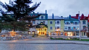 A hotel with a green facade, a black awning, and a sign that reads "Homewood Suites Hilton."