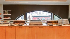 A buffet counter with a view of a building through a large window.