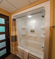 Un baño amplio con una bañera grande, ducha y lavamanos.