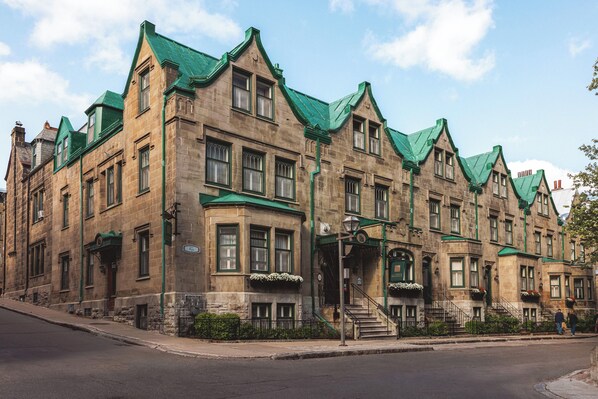 A historic building with multiple stories, green-tiled roofs, and a prominent entrance with steps. - Hotel Chateau Bellevue (Québec City)