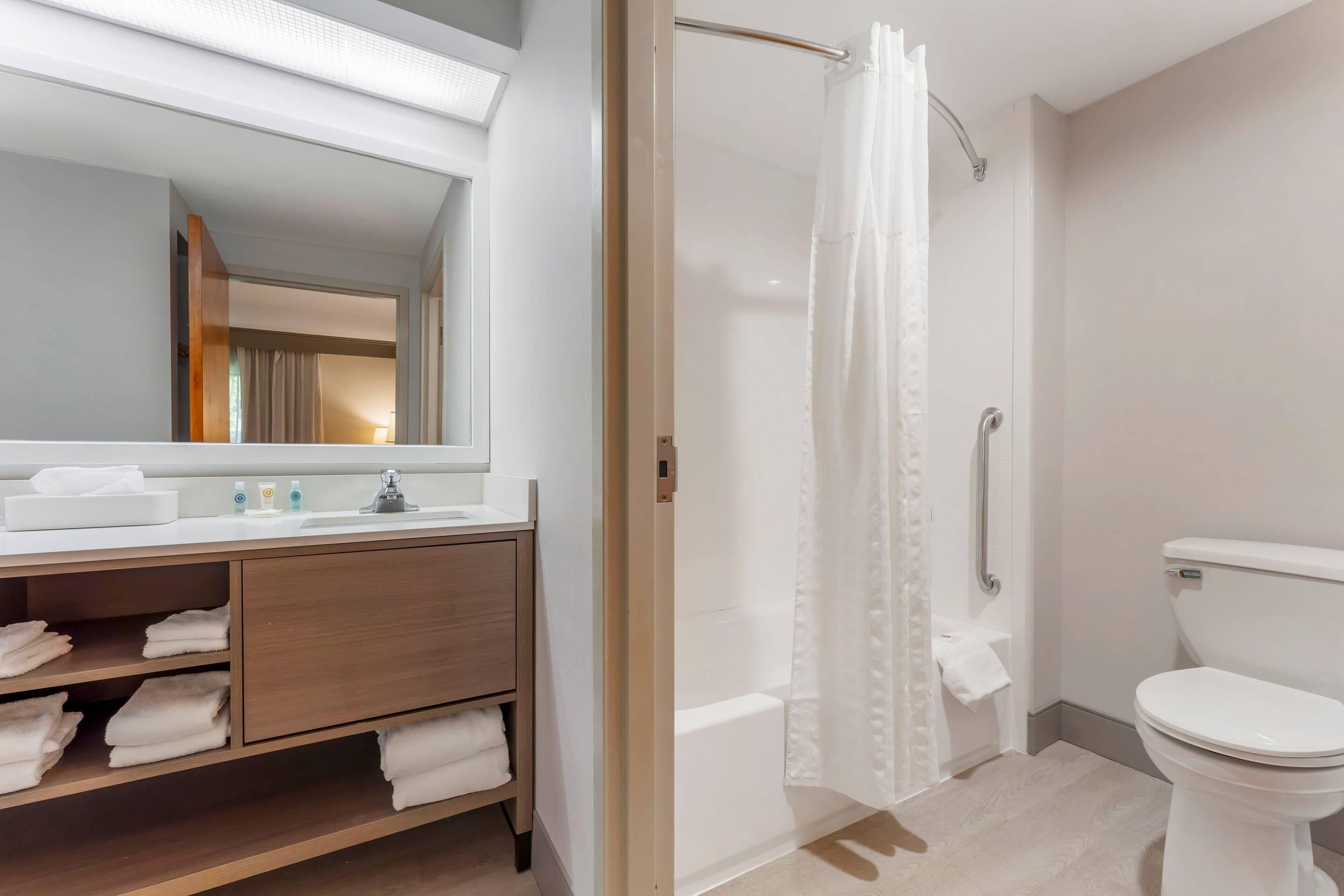 A modern bathroom with a shower, toilet, and vanity.