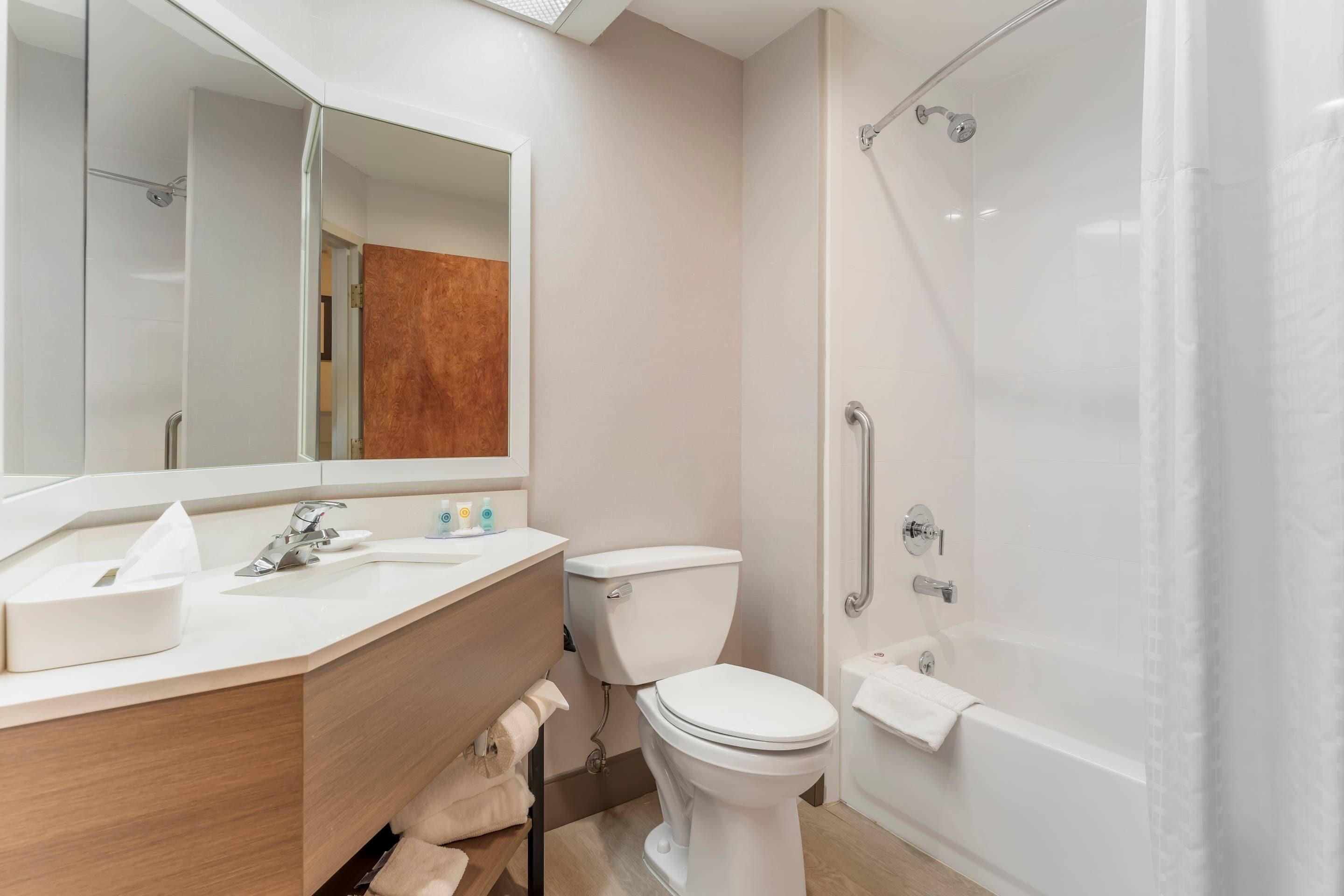 A modern bathroom with a sink, toilet, and shower.