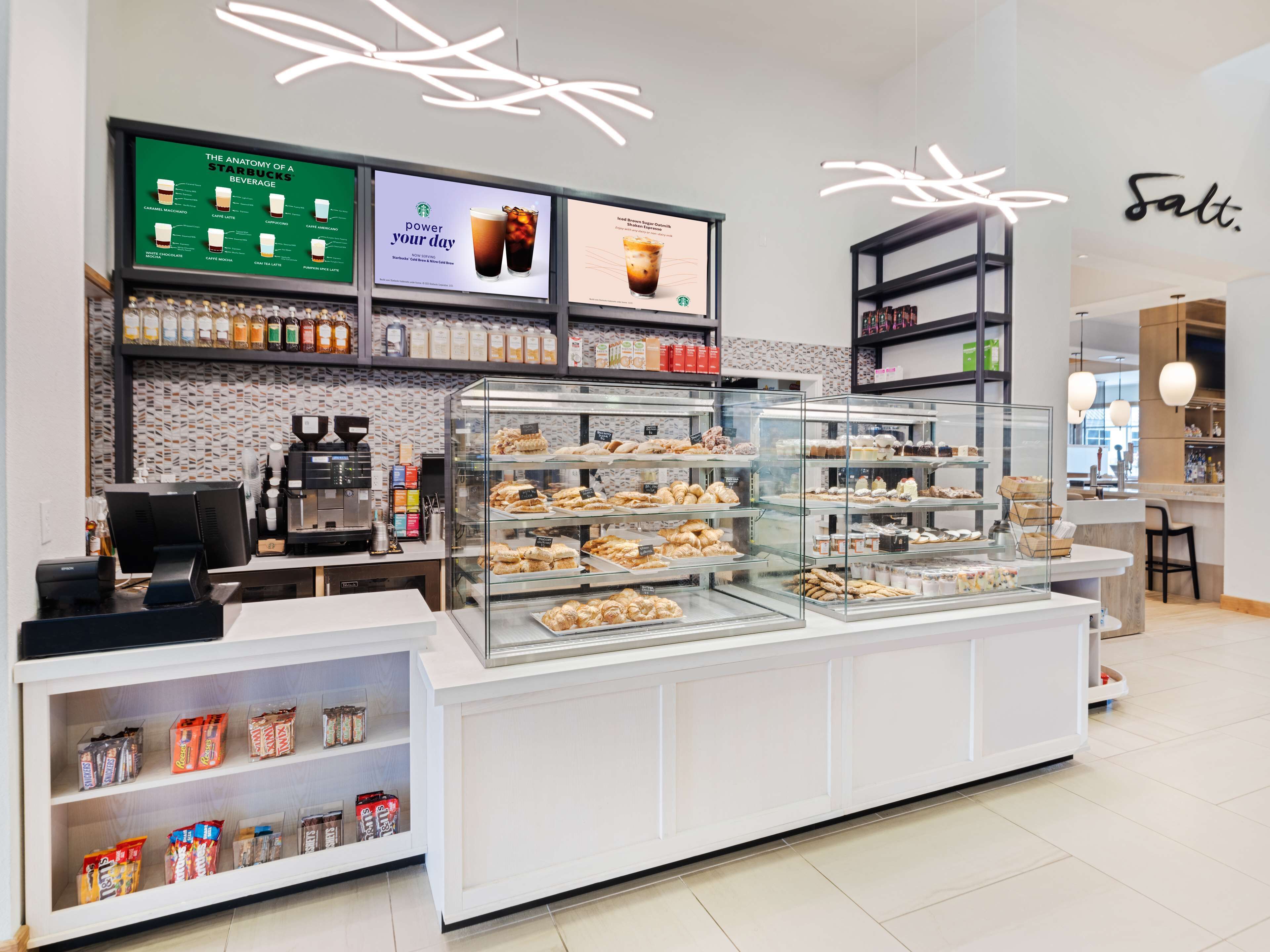 A bakery display with various baked goods and a coffee machine.