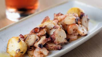 En tallrik med grillad bläckfisk och citronskivor.