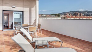 A terrace with sun loungers and a table, overlooking a cityscape. - B&B Hotel Granada Estación (Granada)