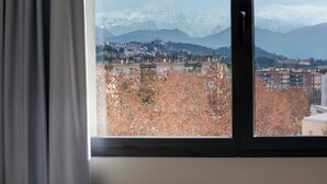 A window view of a cityscape with mountains in the background. - B&B Hotel Granada Estación (Granada)
