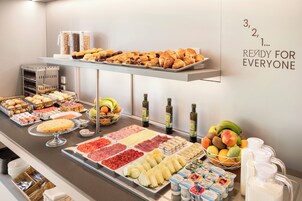 Buffet com diversos itens de comida, incluindo doces, frutas e laticínios.