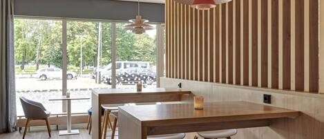A modern dining area with a long wooden table, multiple chairs, and a unique ceiling design.