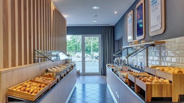 Zona de bufé con diversas opciones de comida y vistas al exterior.