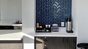 A modern kitchen with a herringbone tile backsplash, a coffee maker, and a microwave. - Motel 6 Ogden, UT - 21st Street (Ogden)