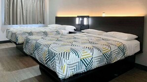A hotel room with two beds, each with patterned bedding, a headboard with built-in lighting, and a window with curtains. - Motel 6 Ogden, UT - 21st Street (Ogden)