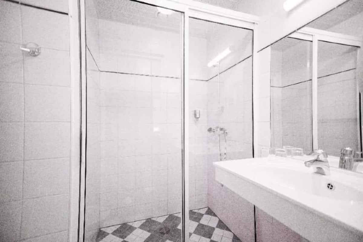 Badkamer | Een bad/douchecombinatie, een haardroger, handdoeken