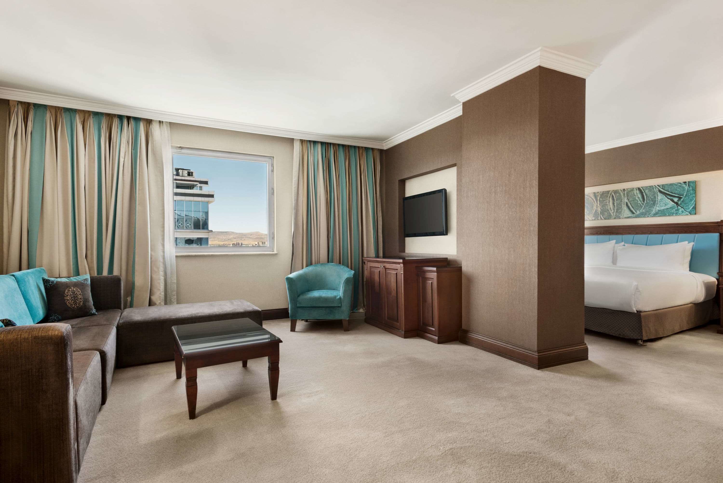 A hotel room with a sofa, armchair, and a bed.