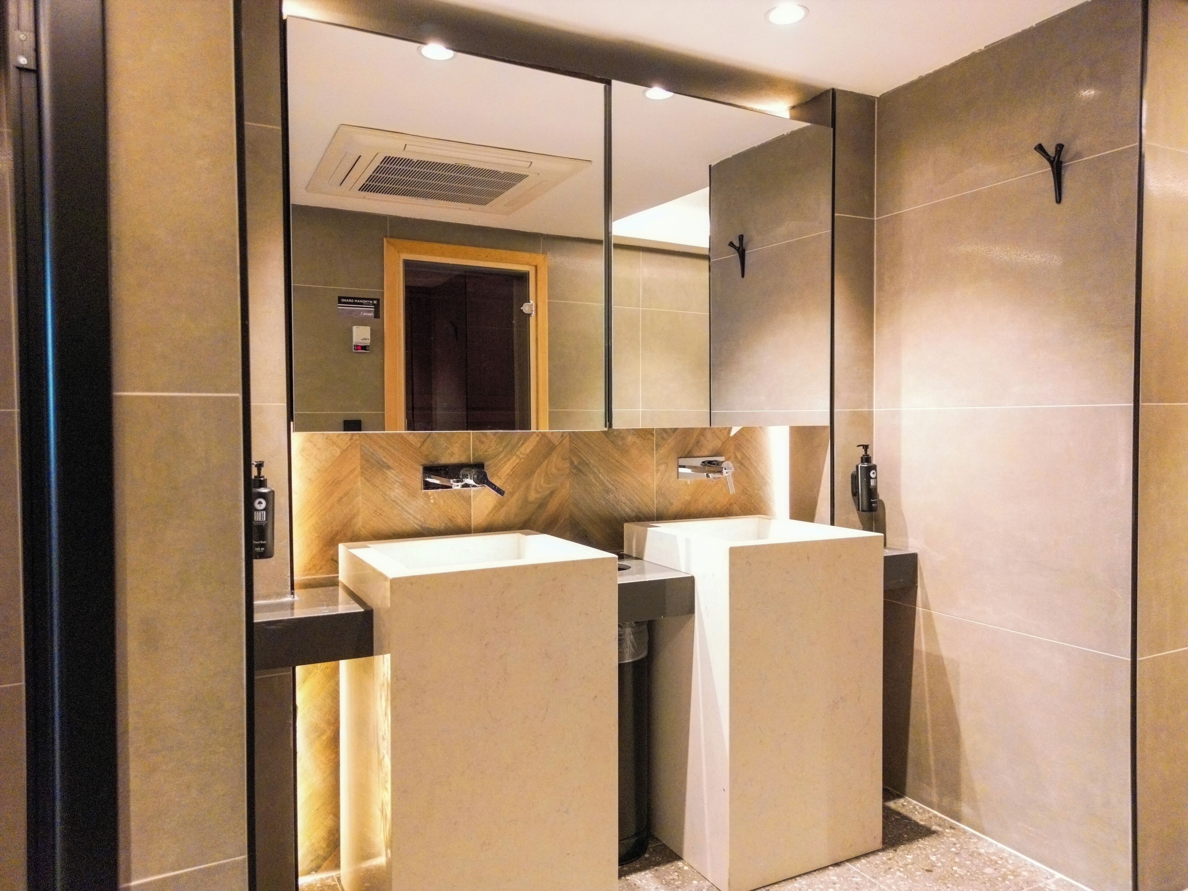 A modern bathroom with two sinks, a mirror, and a shower area.