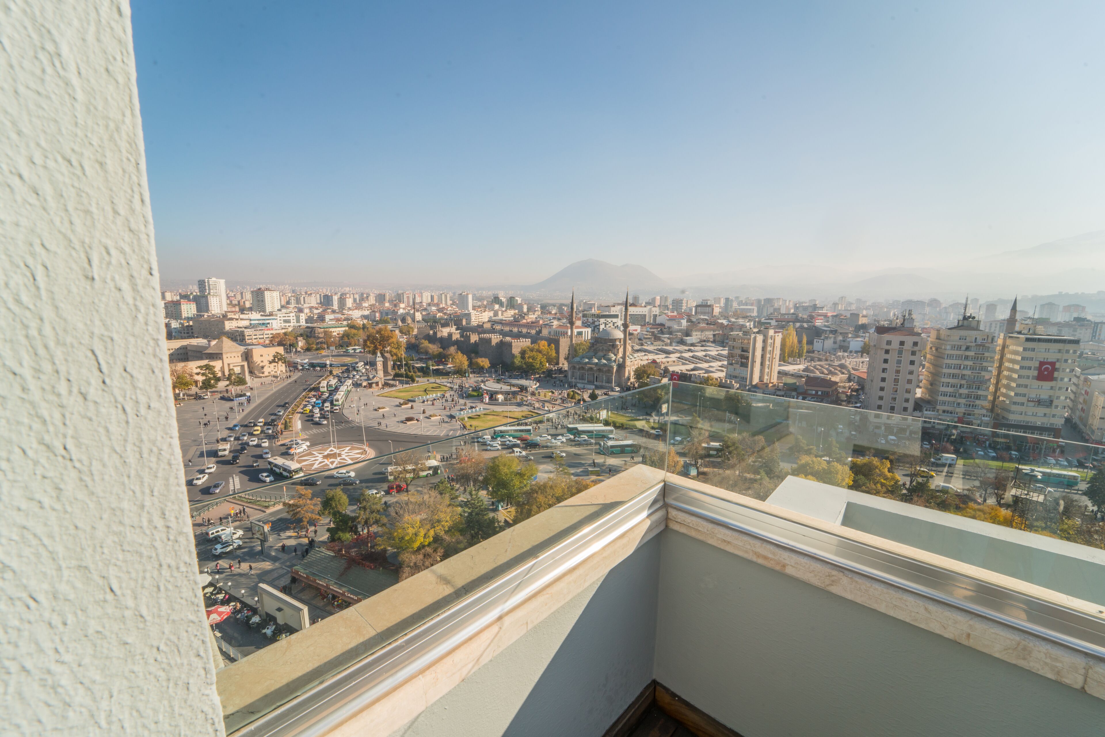 Paisagem urbana com vista para edifícios, estradas e uma montanha ao longe.