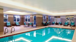 An indoor swimming pool with clear water, surrounded by lounge chairs and tables. - Residence Inn by Marriott Colorado Springs North/Air Force Academy (Colorado Springs)