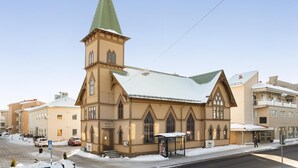 Une église dotée d’un clocher imposant et de fenêtres en arc de cercle.
