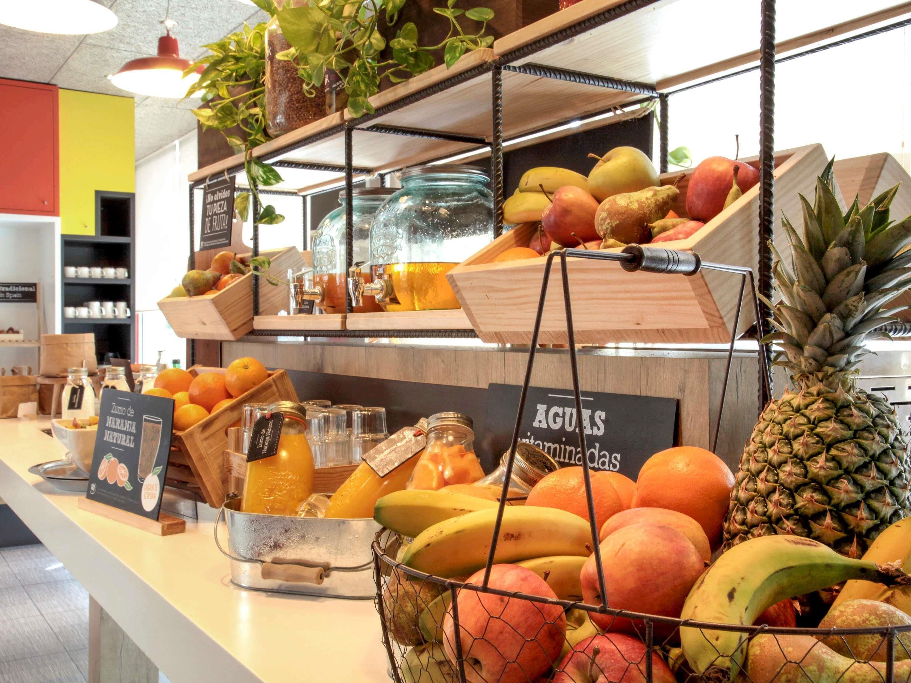 Una exhibición de frutas con diversas frutas y un cartel que indica 'AGUAS'.