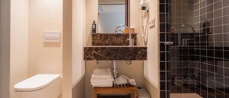 Un baño moderno con inodoro, lavamanos y ducha.