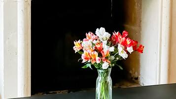Una chimenea con un florero y un candelabro sobre la repisa.