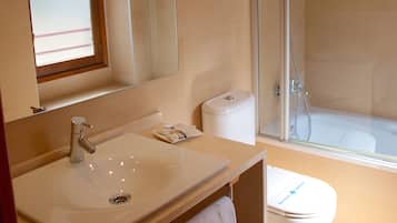 Un baño con lavamanos, espejo, toallero, inodoro y ducha.