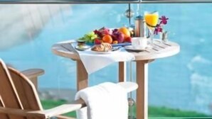 Une table à manger avec vue sur la mer, une chaise et une serviette.