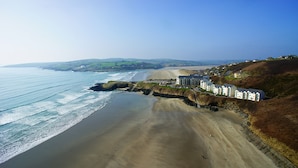 Un hôtel en bord de mer offrant une vue sur la plage, situé sur une falaise surplombant l’océan.
