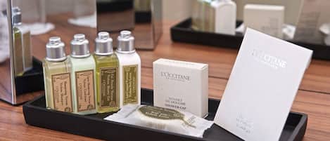 A display of L'OCCITANE products including shampoo, conditioner, and shower cap.