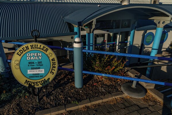 A sign for the Eden Killer Whale Museum with operating hours.