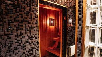 A bathroom with a tiled wall, a wooden door, and a red toilet.