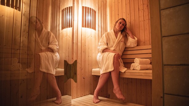 A wooden sauna with benches and towels.