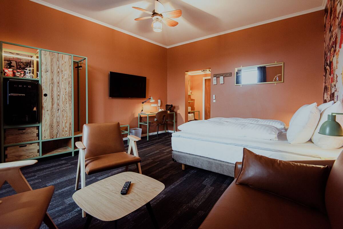 Une chambre d’hôtel équipée d’un lit, d’un bureau, d’une chaise, d’une télévision et d’une armoire.