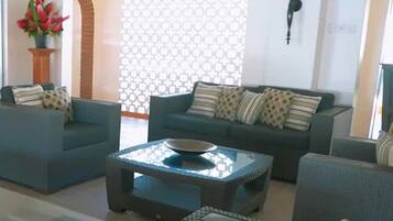 Una sala de estar moderna con dos sofás, una mesa de centro y una pared con diseño.