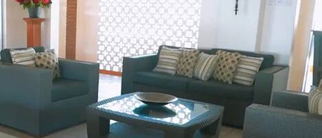 A modern living room with two sofas, a coffee table, and a patterned wall.