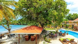 Um resort com piscina, área de estar externa e espaço coberto.