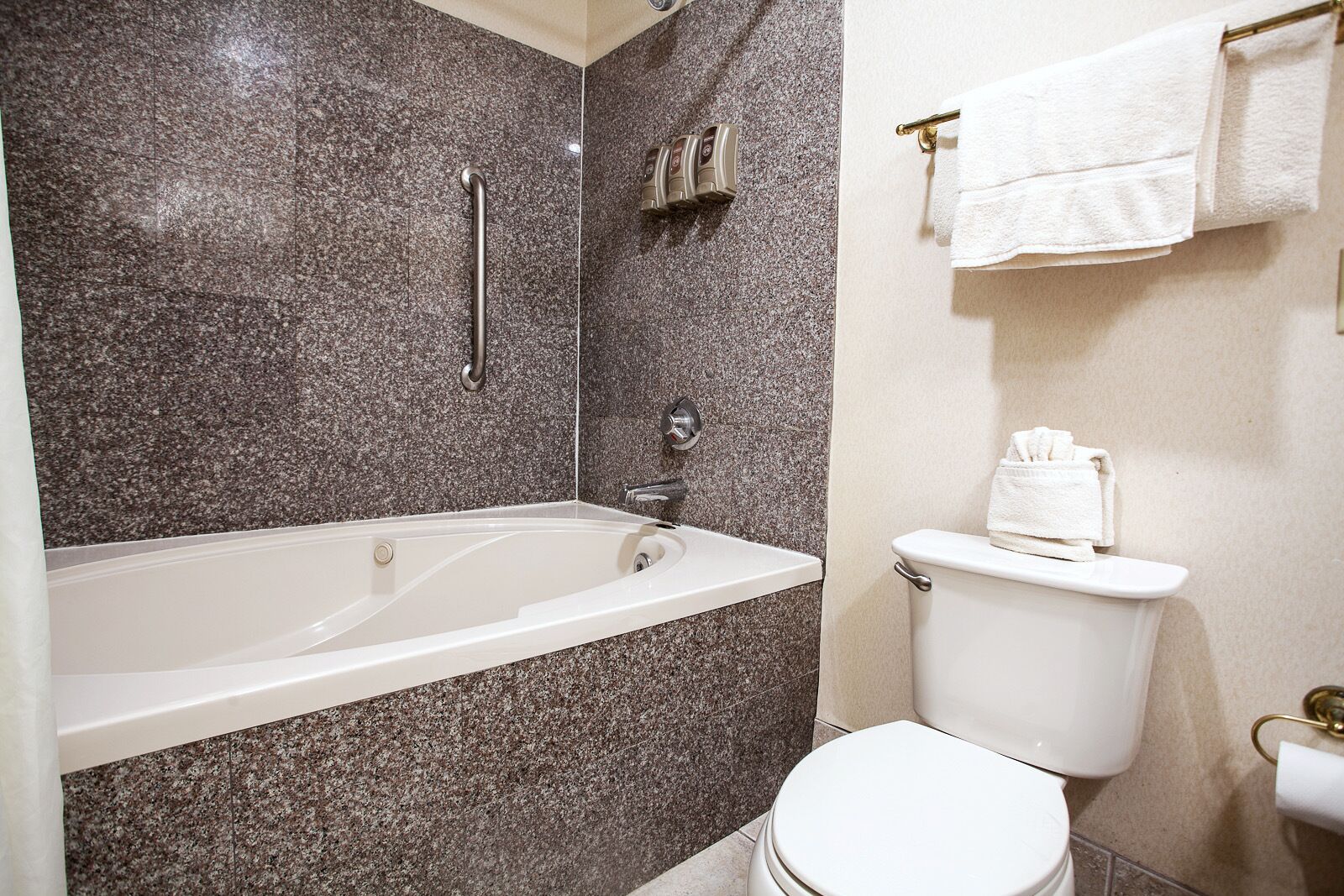 Ein Badezimmer mit Badewanne, Toilette und Handtuchhalter.