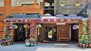 A building with a wooden facade, a registration sign, and multiple flower planters. - Vail Run Resort (Vail)