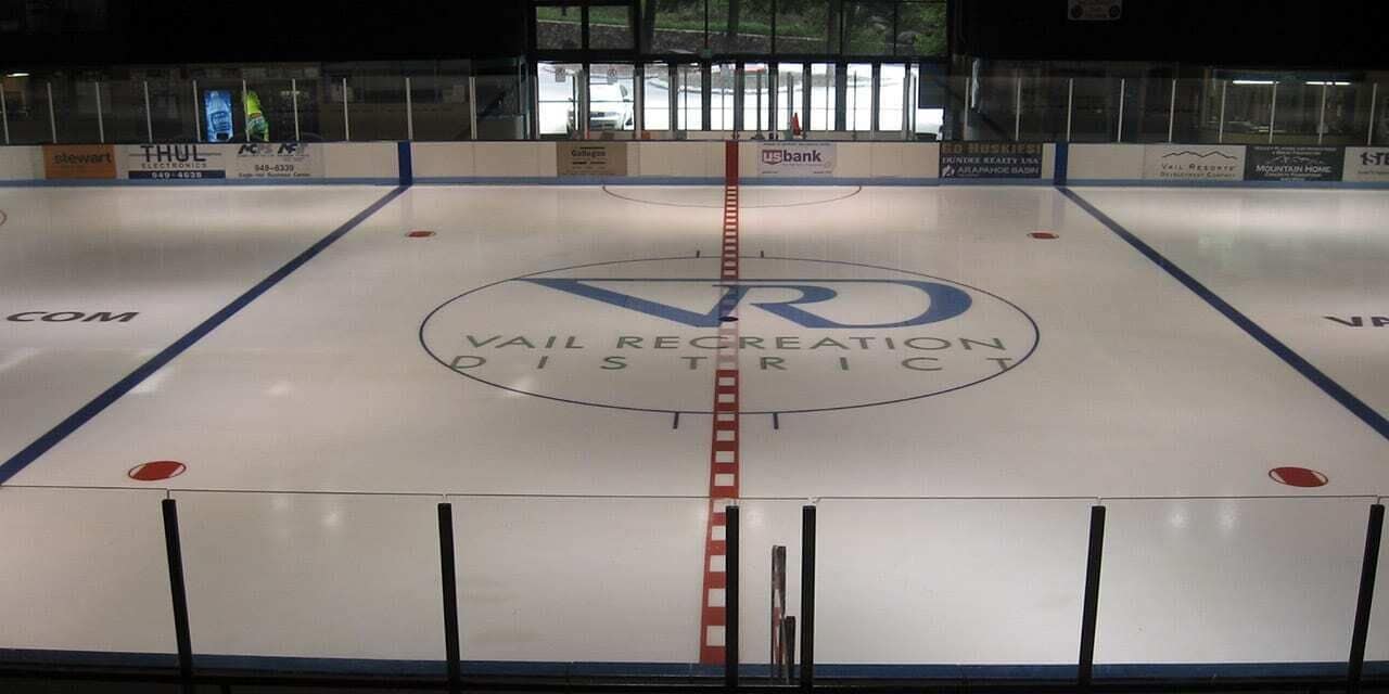 An indoor ice hockey rink with advertisements for US Bank and Thul Electronics.