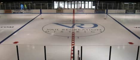An indoor ice hockey rink with advertisements for US Bank and Thul Electronics.
